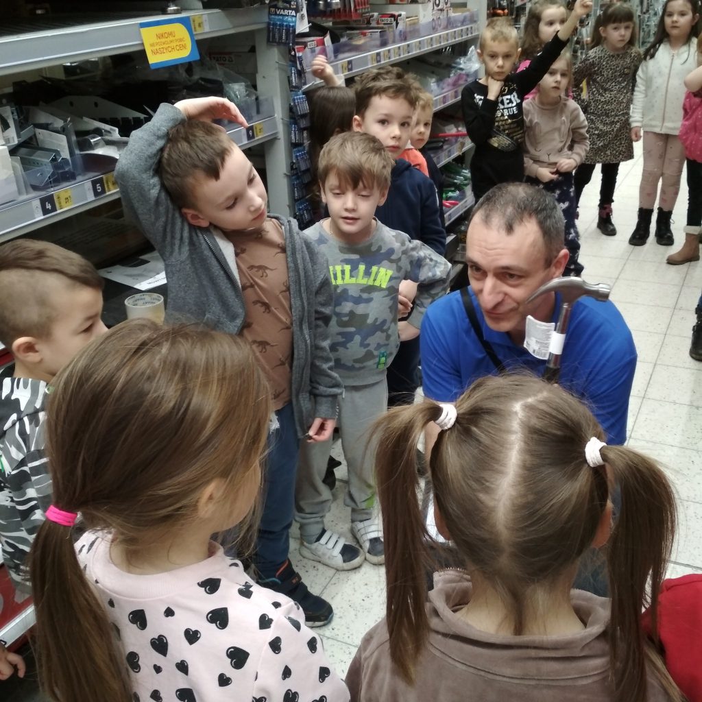 Mężczyzna pokazuje dzieciom jedno z narzędzi, które można kupić w sklepie
