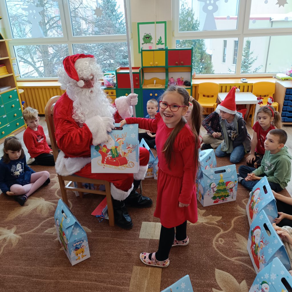 Św. Mikołaj wręcza prezenty dla dzieci. 