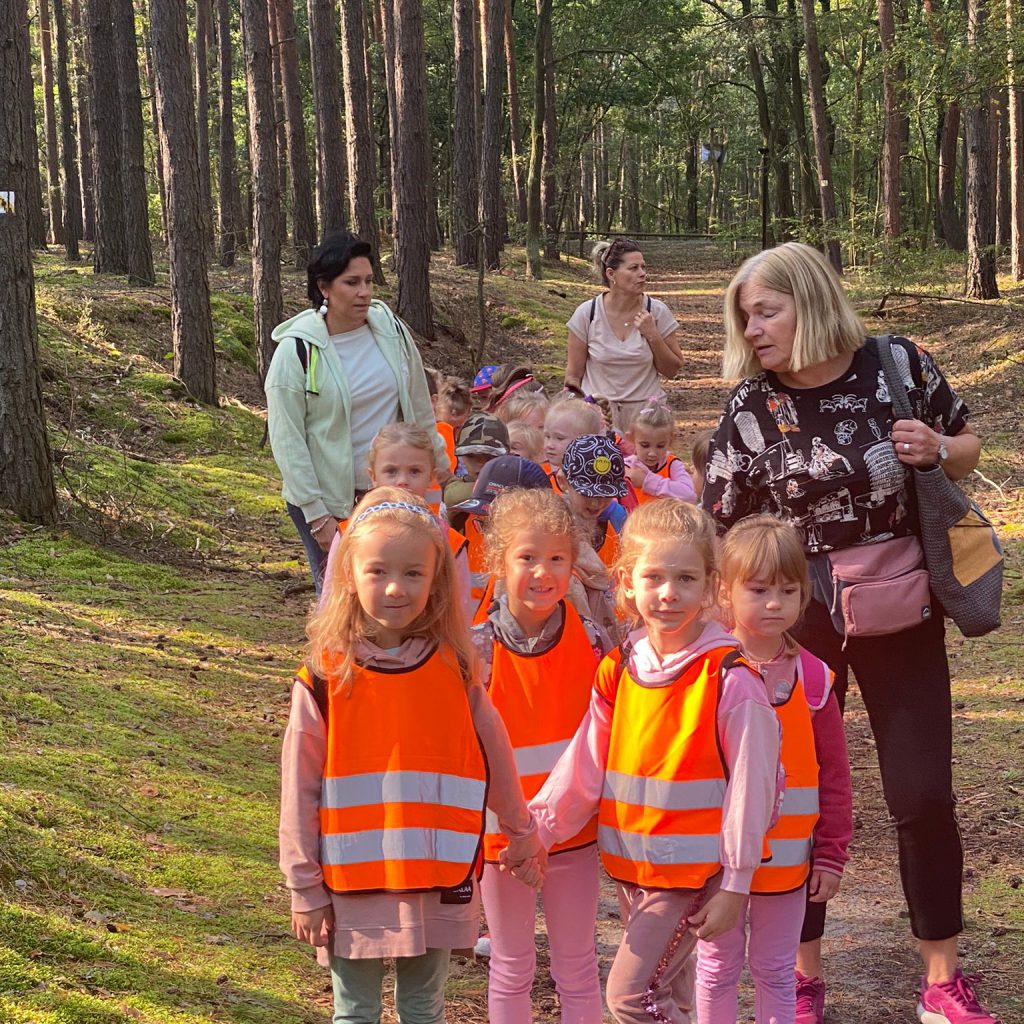 dzieci wraz z dorosłymi znajdują się na leśnej ścieżce