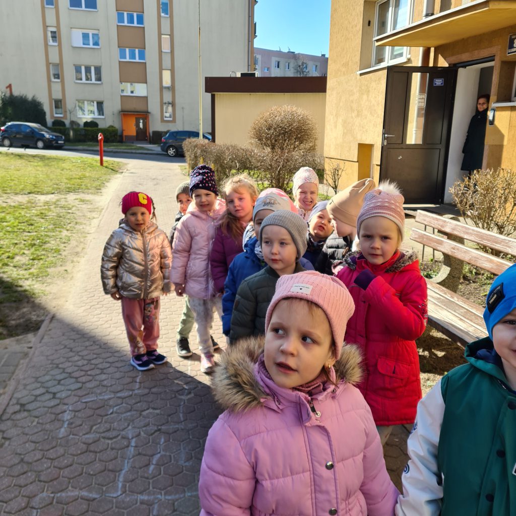 grupa dzieci spaceruje po chodniku