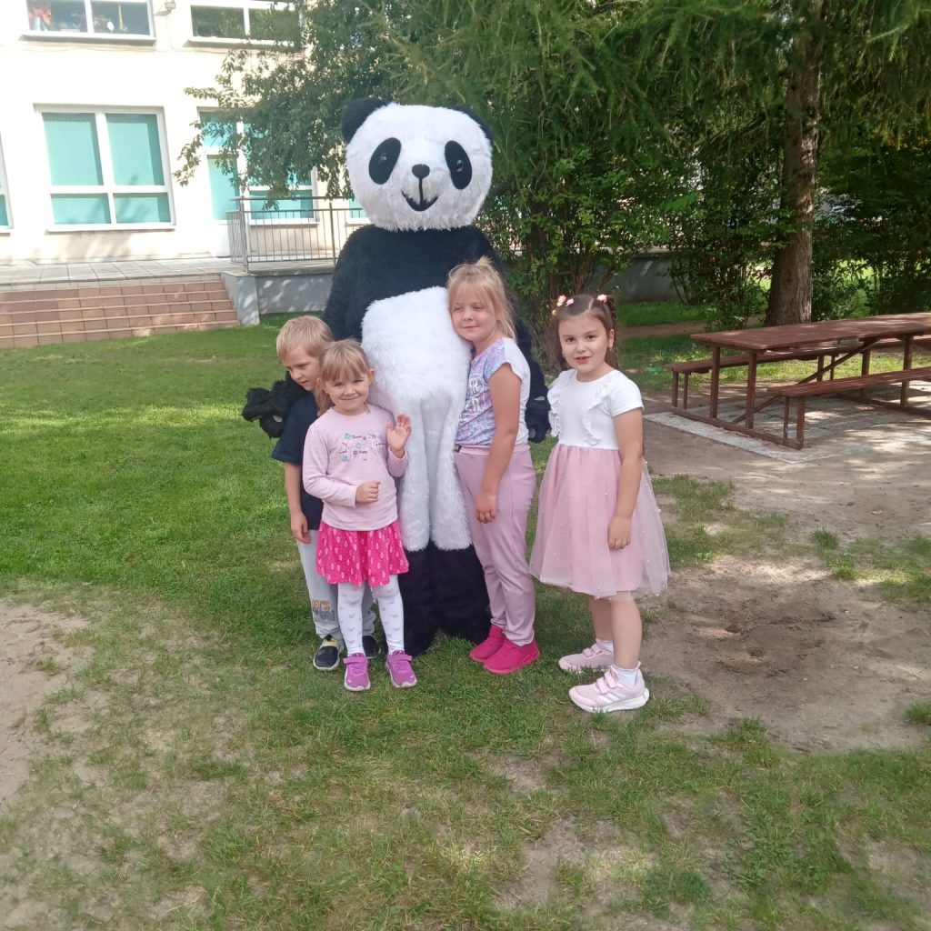 dzieci pozują z pandą maskotką