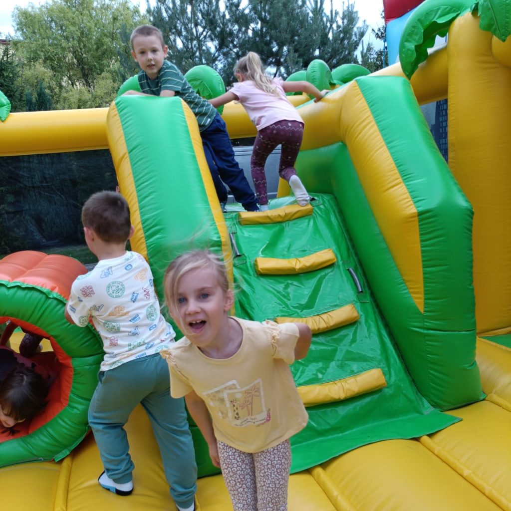 dzieci korzystają z dmuchanego zamku