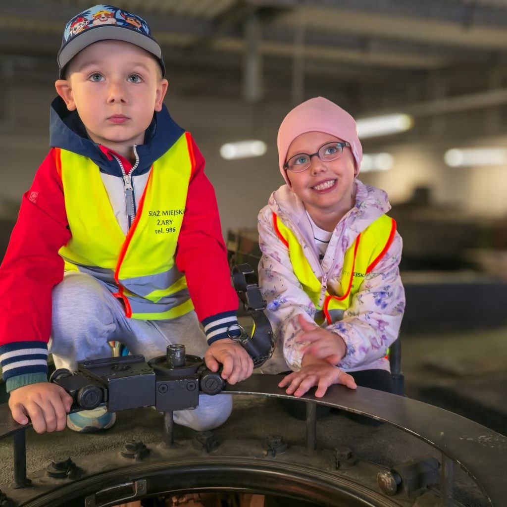 chłopiec i dziewczynka na pojeźdie pancernym