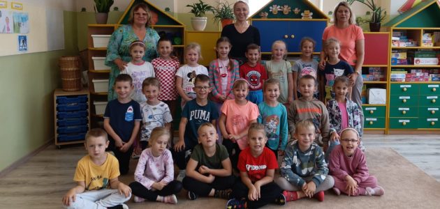 grupa dzieci pozuje wraz z wychowawcami i pracownikiem obsługi