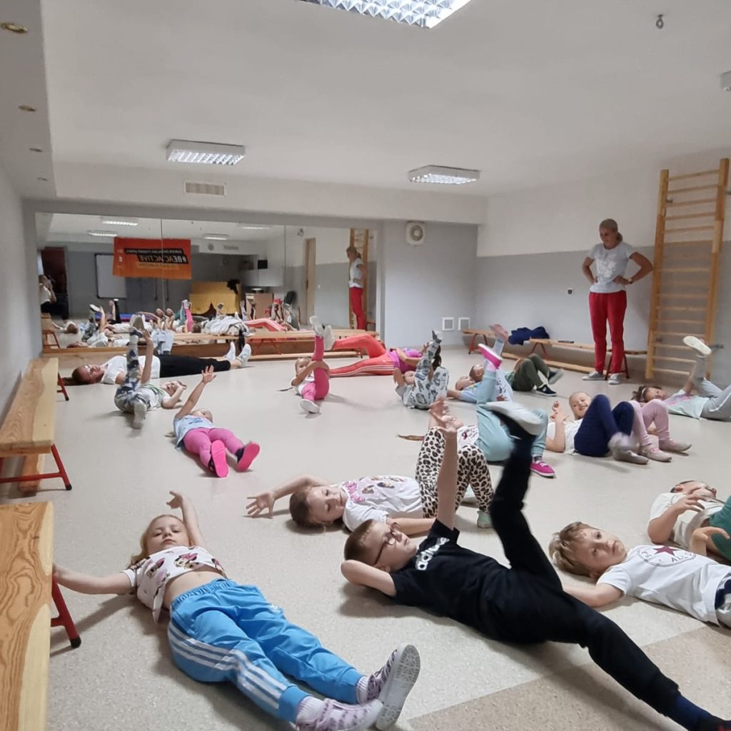 dzieci wykonują ćwiczenia na sali gimnastycznej