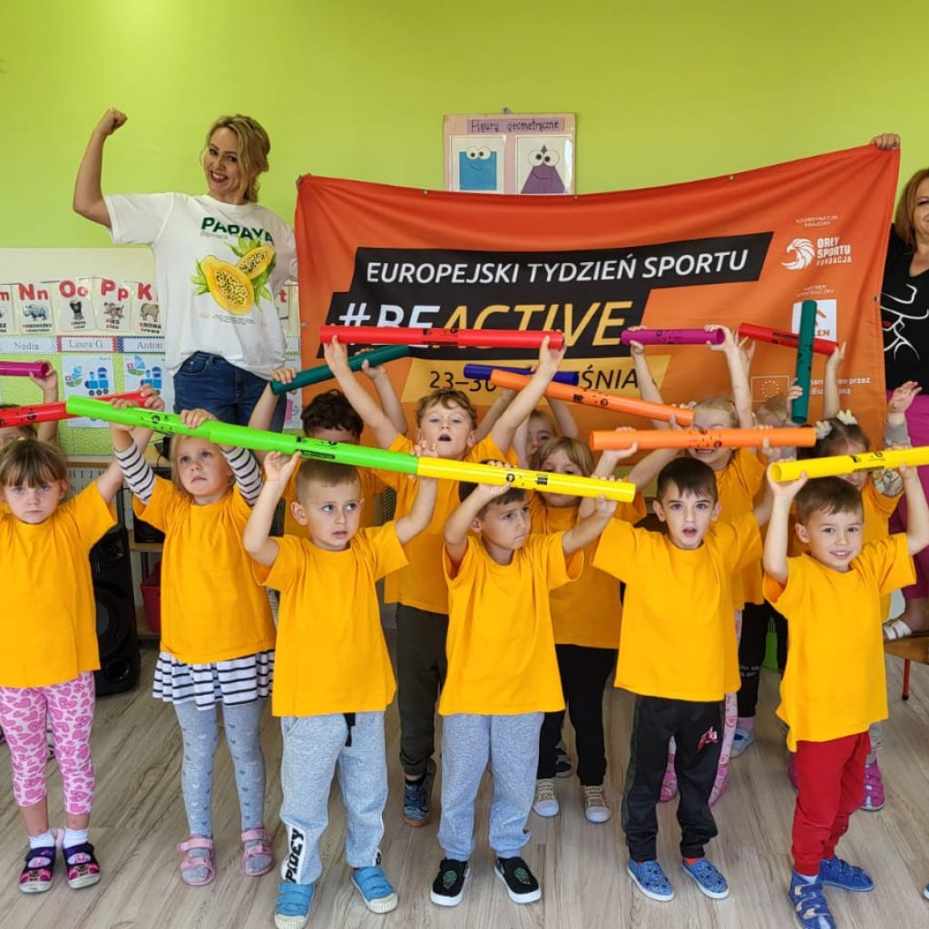 dzieci pozują z opiekunami na tle banera # beactive