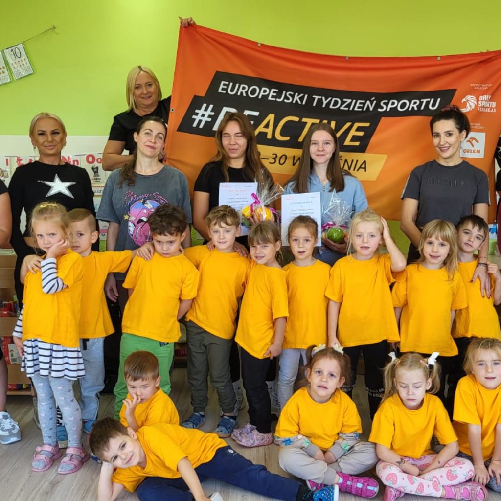 dzieci pozują z rodzicami i opiekunami na tle banera #beactive