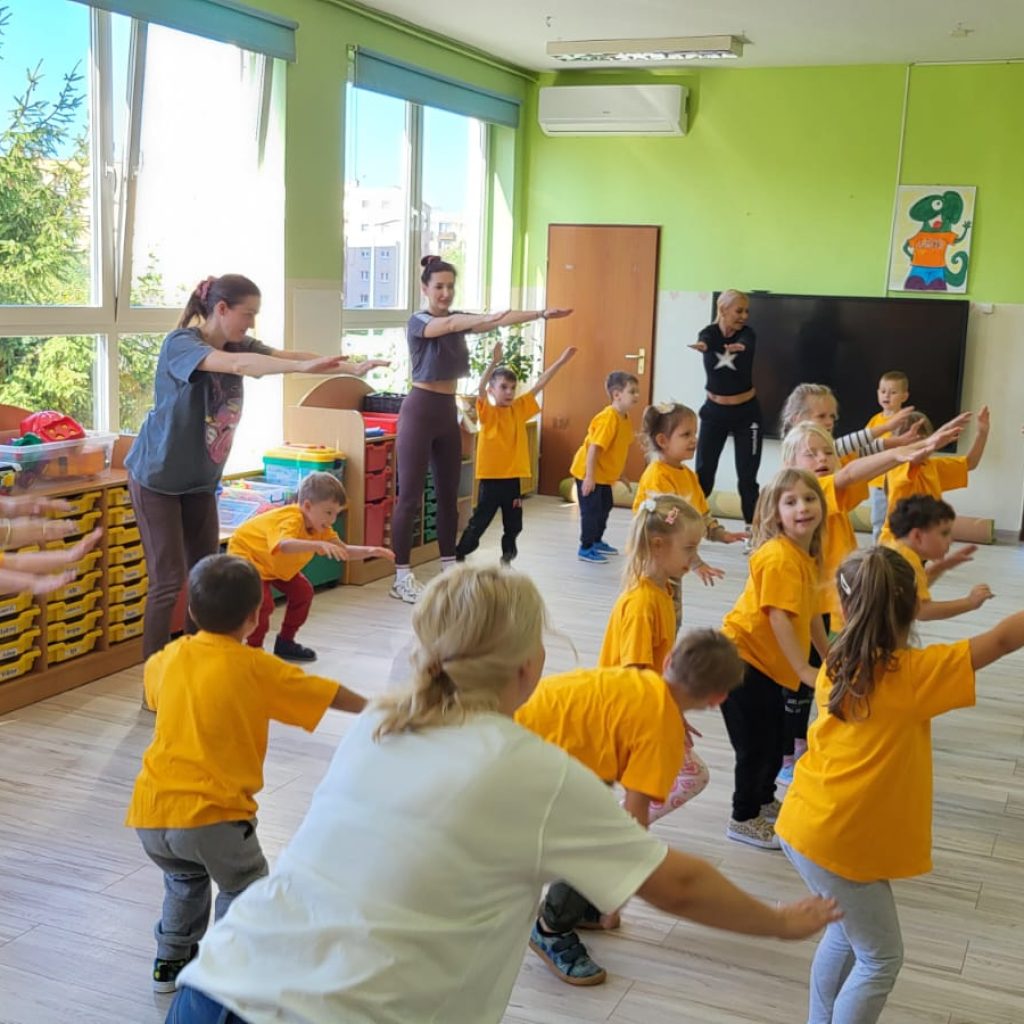 dzieci i rodzice wykonują ćwiczenia gimnastyczne