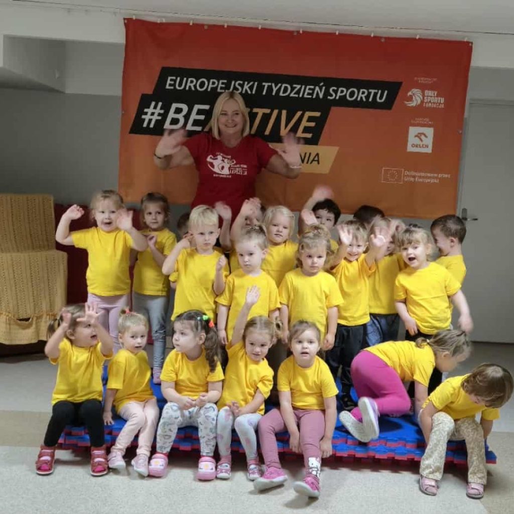 dzieci wraz z Panią dyrektor pozują na tle banera #beactive