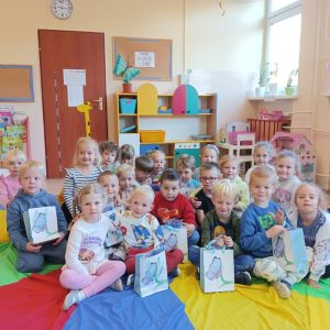 grupa dzieci pozuje siedząc na dywanie