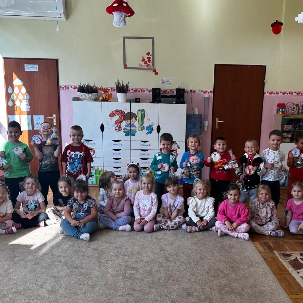 grupa dzieci pozuje na dywanie