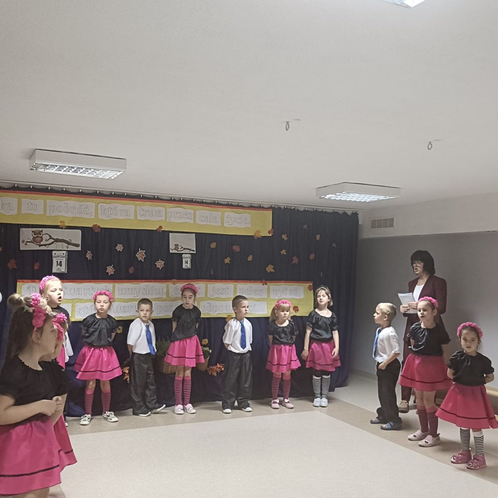 Dzieci ustawione w podkowę deklamują wiersz