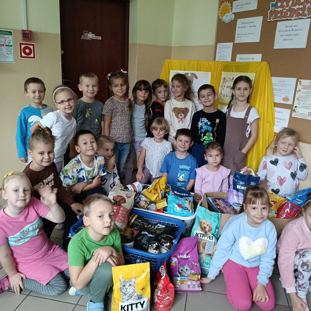 grupa dzieci na tle zebranej karmy dla zwierząt