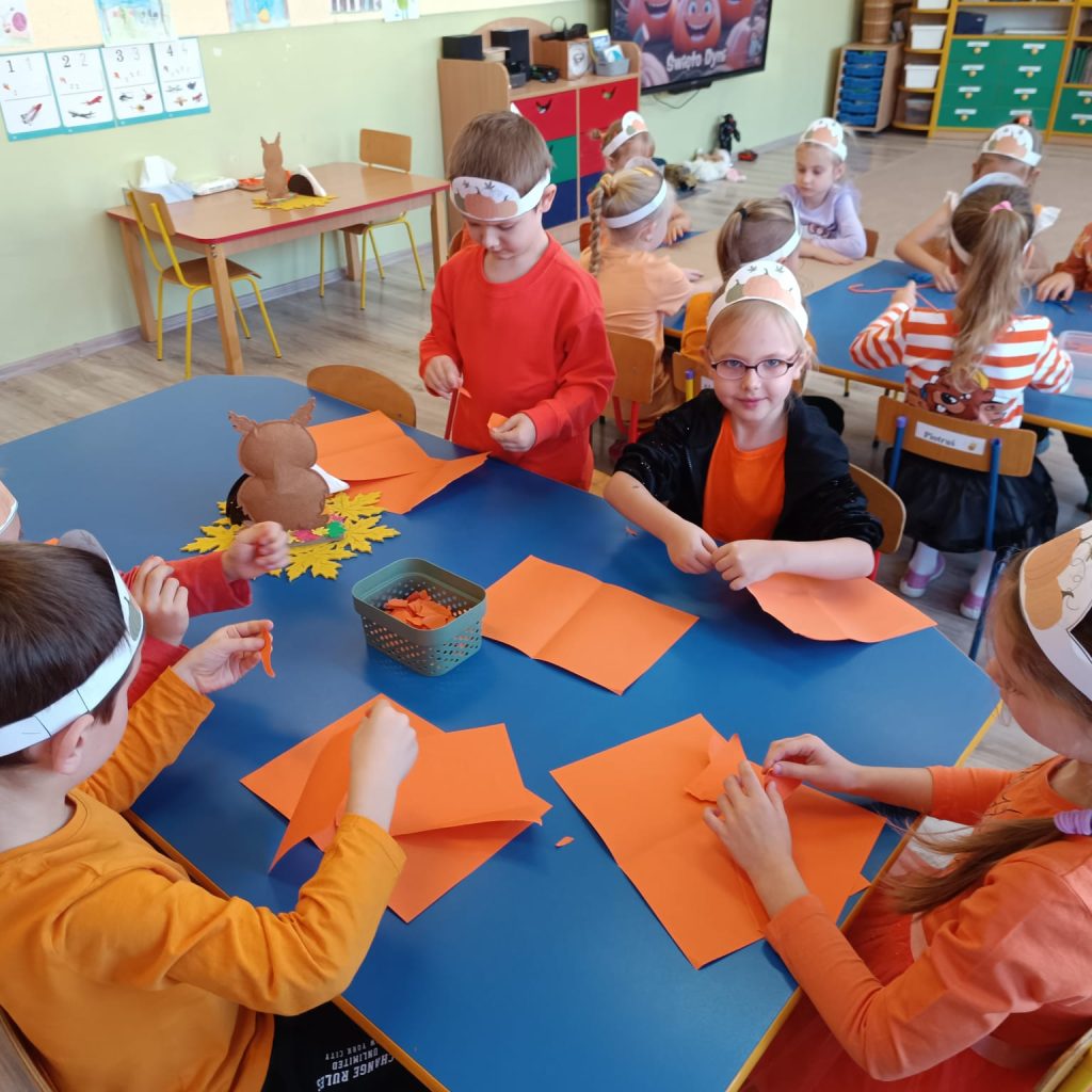 dzieci wykonują przy stolikach prace plastyczne