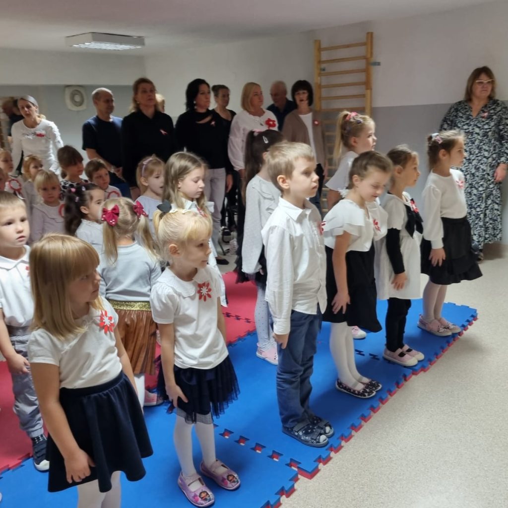 dzieci i dorośli śpiewają hymn Polski