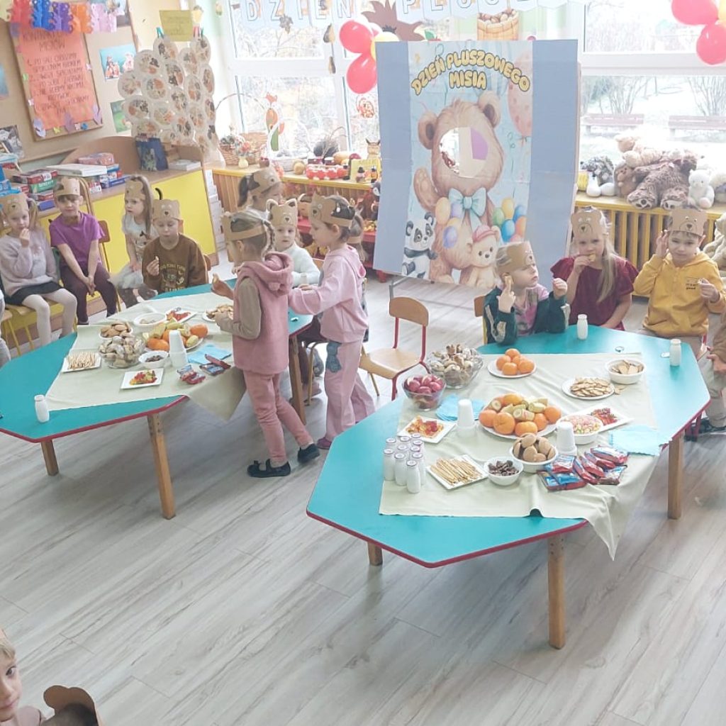 grupa dzieci częstuje się słodkim poczęstunkiem 