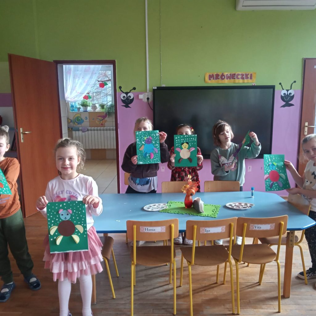 grupa dzieci pozuje z wykonanymi przez siebie obrazkami misiów
