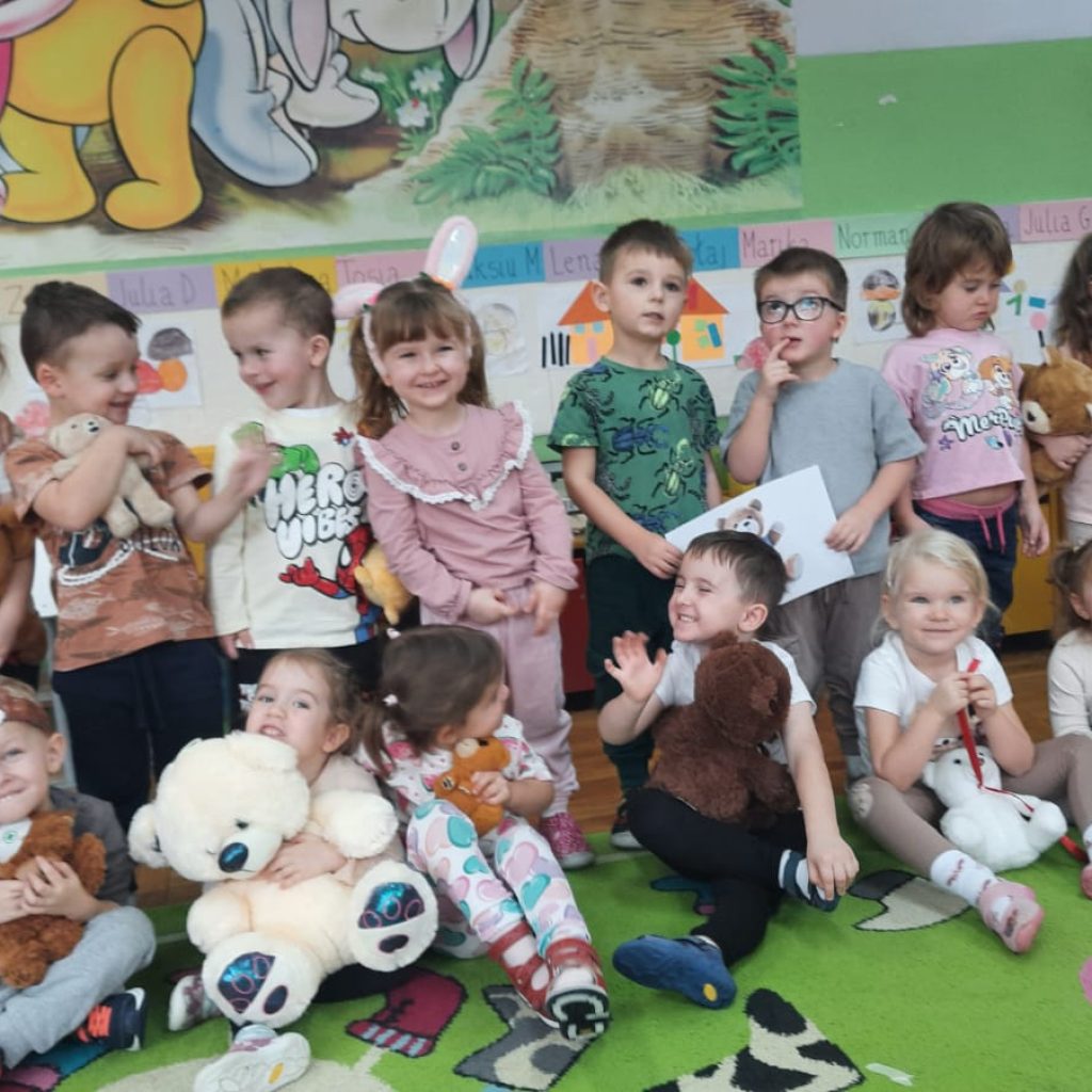 grupa dzieci pozuje z pluszakami
