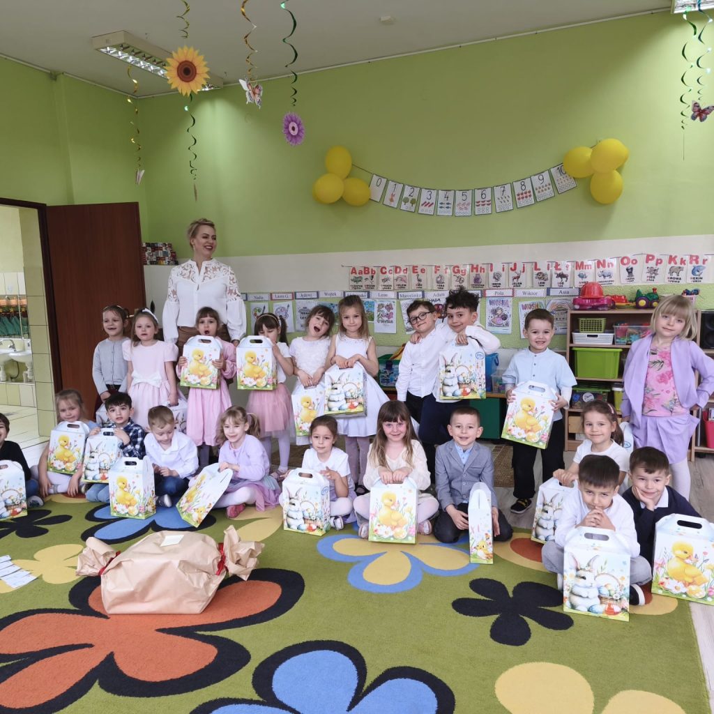 dzieci pozują wraaz z nauczycielką i prezentami od zajączka