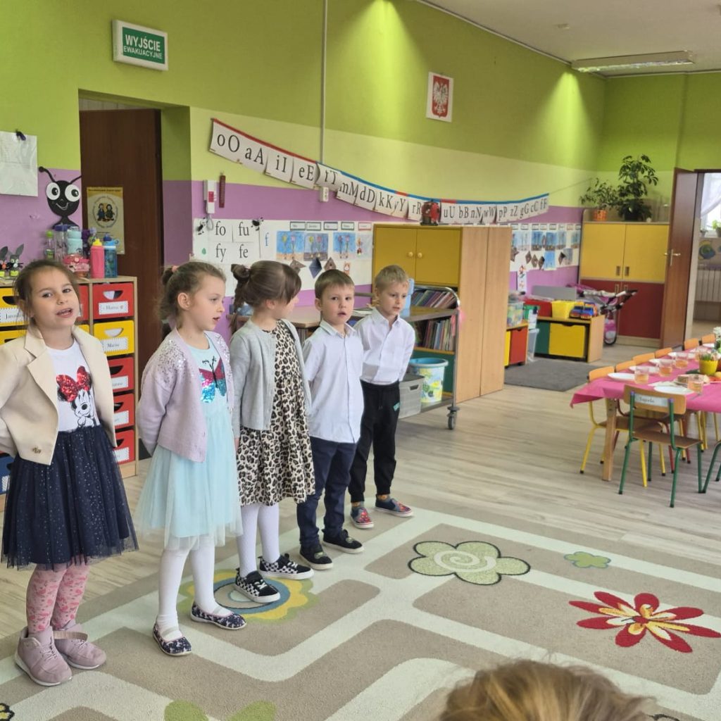 dzieci śpiewają piosenkę ubrane odświętnie