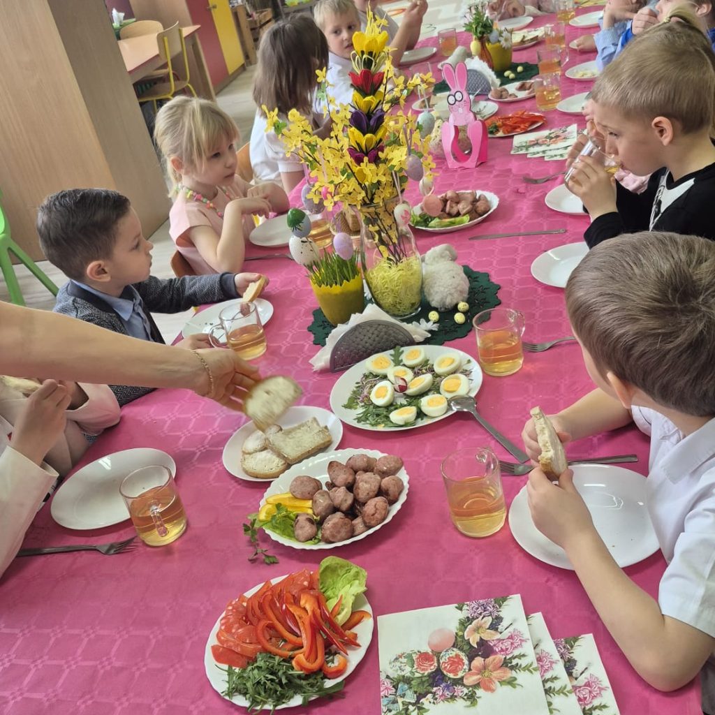 dzieci jedzą śniadanie przy odświętnym stole
