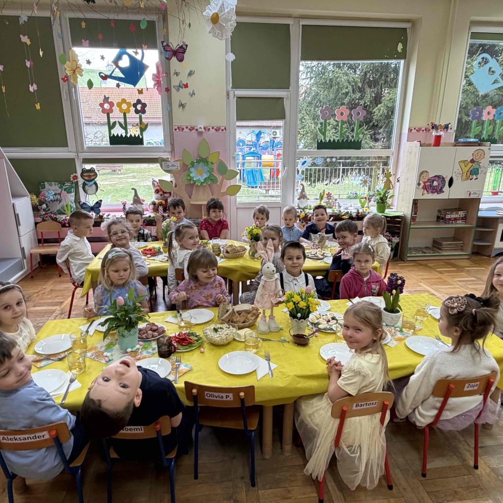 dzieci siedzą przy stołach ubranych na żółto